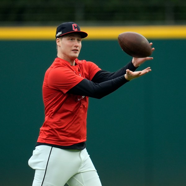 Cleveland Guardians pitcher Tim Herrin catches a football during a workout Wednesday, Oct. 16, 2024, in Cleveland, ahead of Game 3 of the baseball AL Championship Series. (AP Photo/Sue Ogrocki)