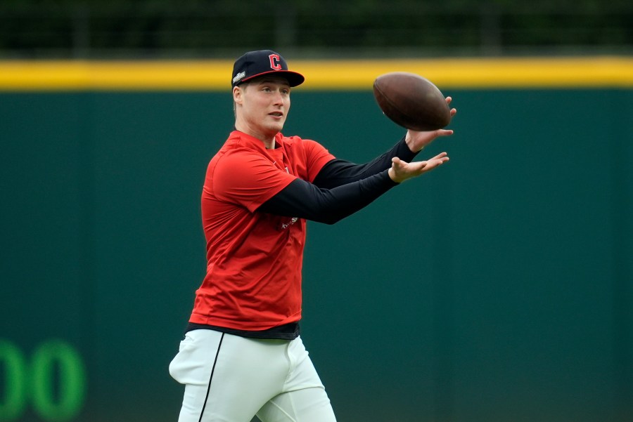 Cleveland Guardians pitcher Tim Herrin catches a football during a workout Wednesday, Oct. 16, 2024, in Cleveland, ahead of Game 3 of the baseball AL Championship Series. (AP Photo/Sue Ogrocki)