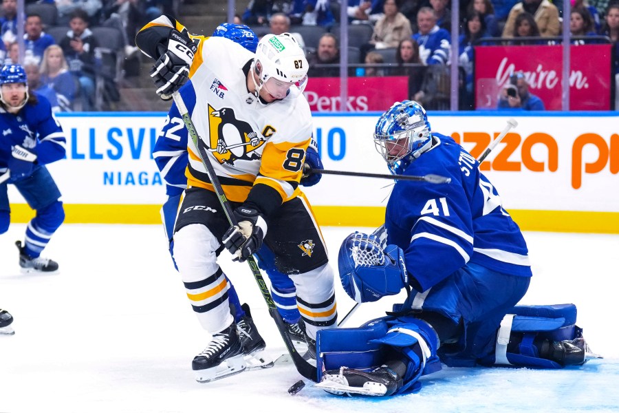 Toronto Maple Leafs goaltender Anthony Stolarz, right, saves a shot by Pittsburgh Penguins' Sidney Crosby (87) during third-period NHL hockey game action in Toronto, Saturday, Oct. 12, 2024. (Chris Young/The Canadian Press via AP)