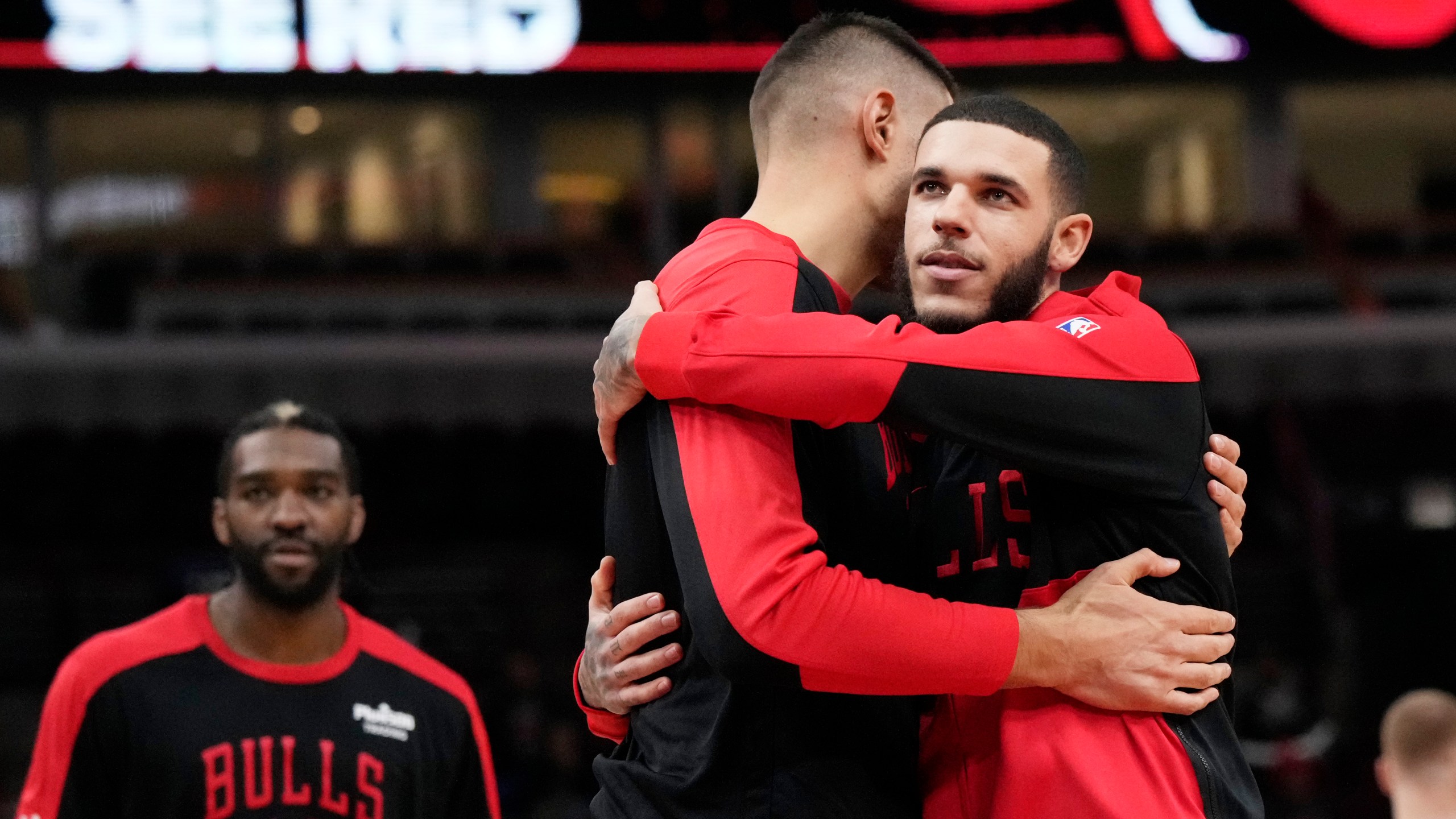 Chicago Bulls guard Lonzo Ball, right, hugs center Nikola Vucevic before an NBA preseason basketball game against the Minnesota Timberwolves in Chicago, Wednesday, Oct. 16, 2024. (AP Photo/Nam Y. Huh)