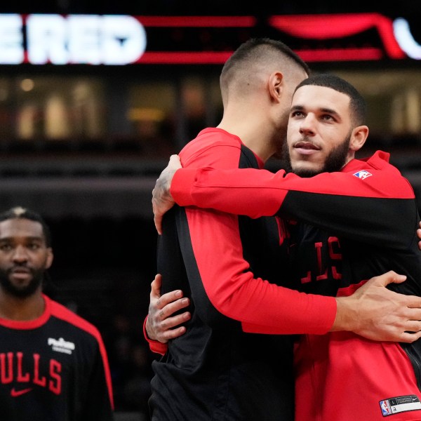 Chicago Bulls guard Lonzo Ball, right, hugs center Nikola Vucevic before an NBA preseason basketball game against the Minnesota Timberwolves in Chicago, Wednesday, Oct. 16, 2024. (AP Photo/Nam Y. Huh)