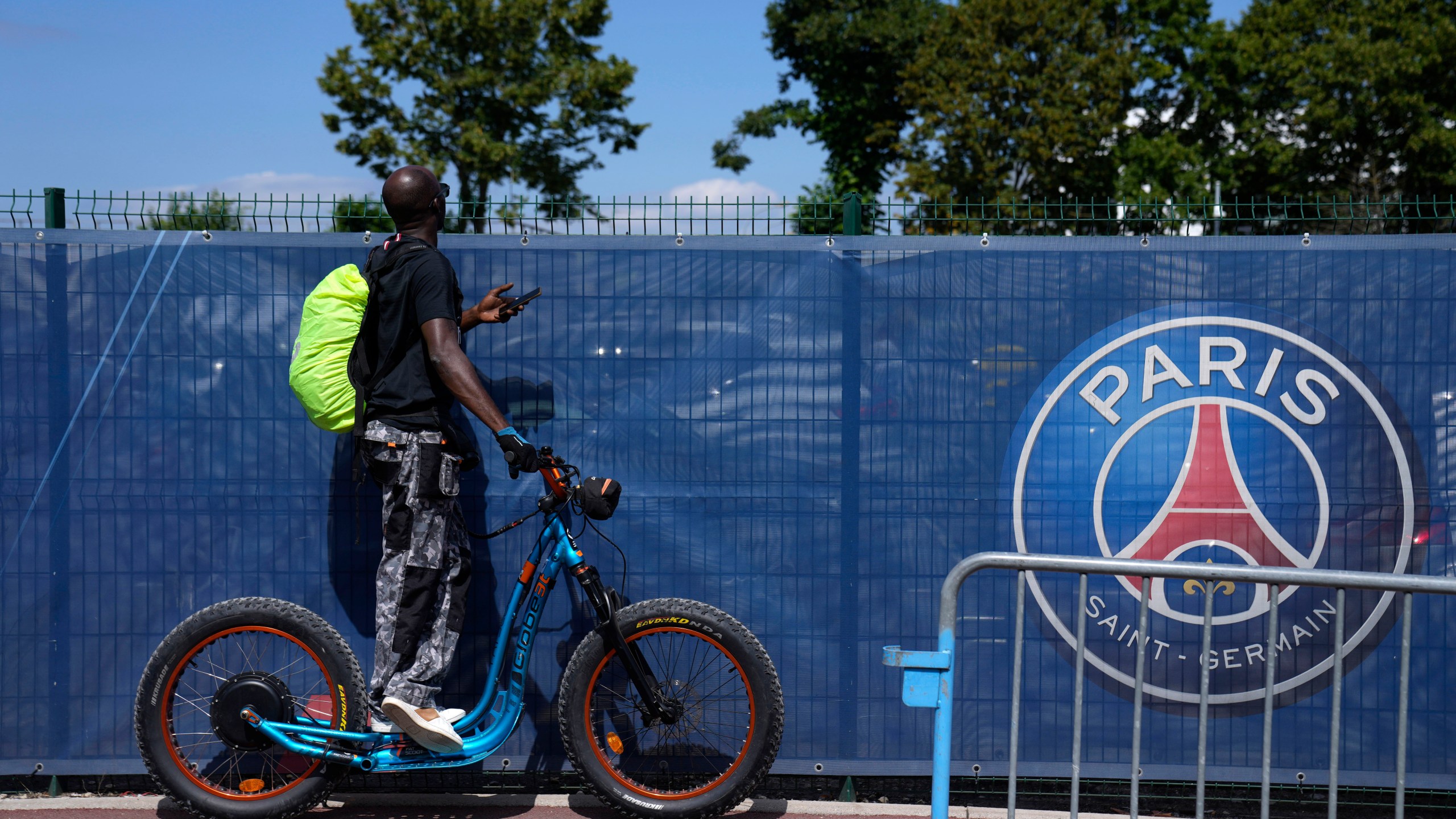 FILE - A soccer fan tries to watch the PSG soccer team training at the Paris Saint-Germain training camp in Saint-Germain-en-Laye, west of Paris, Friday, Aug. 13, 2021. (AP Photo/Francois Mori, File)