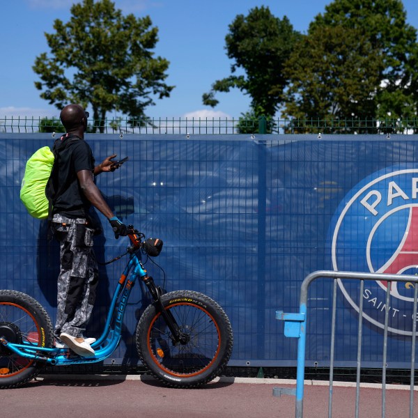 FILE - A soccer fan tries to watch the PSG soccer team training at the Paris Saint-Germain training camp in Saint-Germain-en-Laye, west of Paris, Friday, Aug. 13, 2021. (AP Photo/Francois Mori, File)