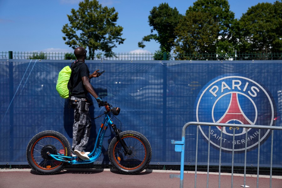 FILE - A soccer fan tries to watch the PSG soccer team training at the Paris Saint-Germain training camp in Saint-Germain-en-Laye, west of Paris, Friday, Aug. 13, 2021. (AP Photo/Francois Mori, File)