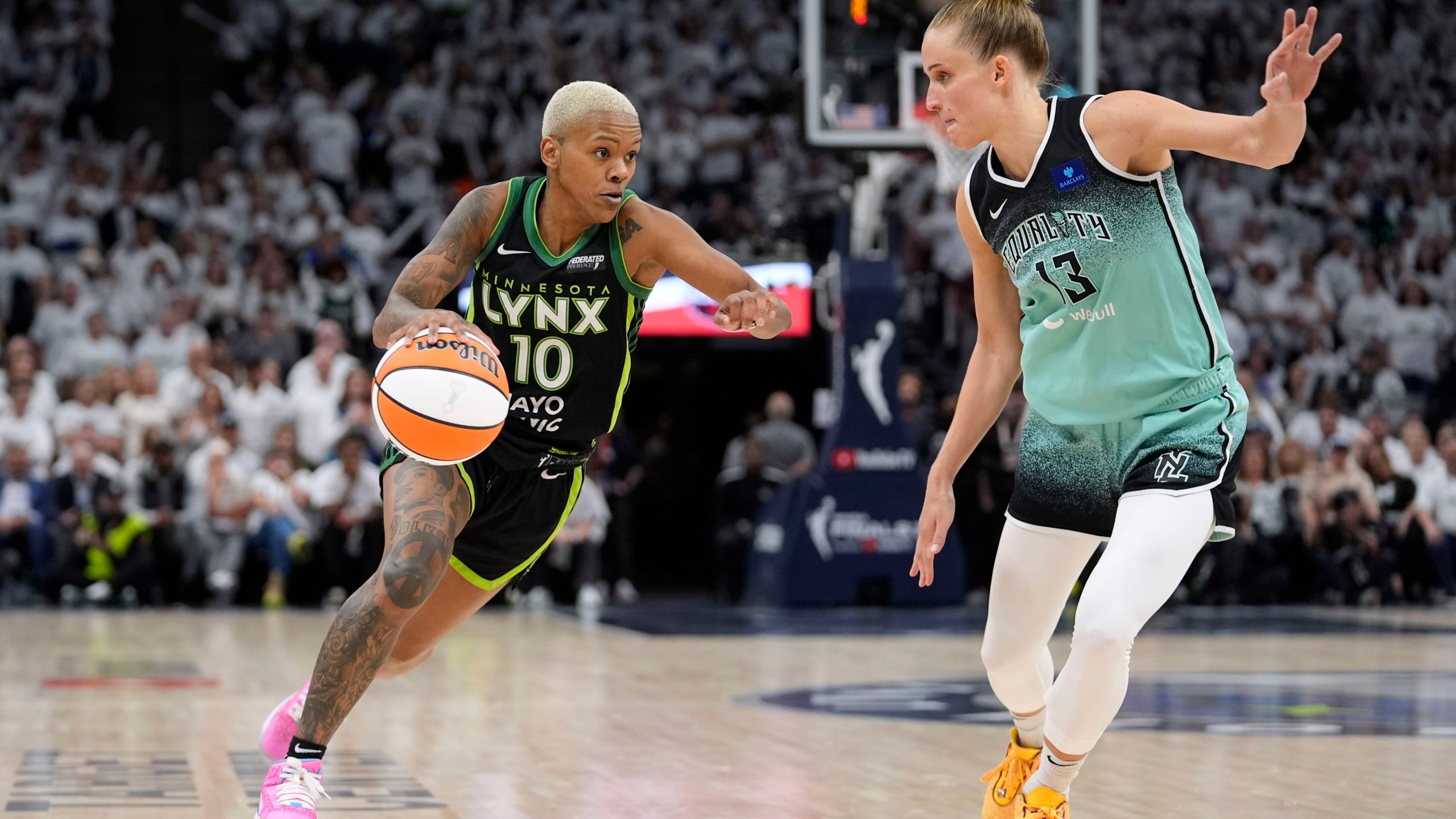 Minnesota Lynx guard Courtney Williams (10) drives past New York Liberty forward Leonie Fiebich (13) during the second half in Game 3 of a WNBA basketball final playoff series, Wednesday, Oct. 16, 2024, in Minneapolis. (AP Photo/Abbie Parr)