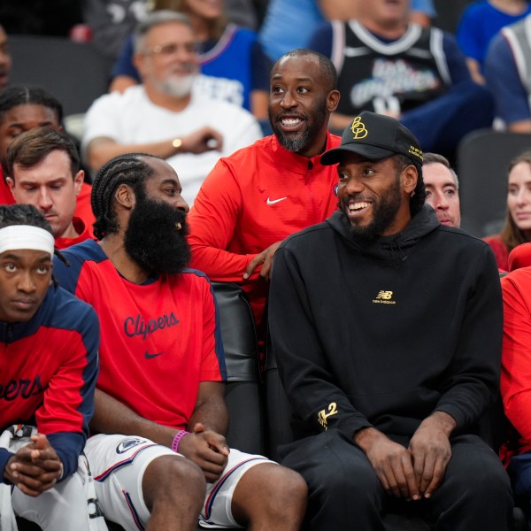 Los Angeles Clippers' James Harden, center left, shares a light moment with Kawhi Leonard during the second half of an NBA preseason basketball game against the Dallas Mavericks Monday, Oct. 14, 2024, in Inglewood, Calif. (AP Photo/Jae C. Hong)