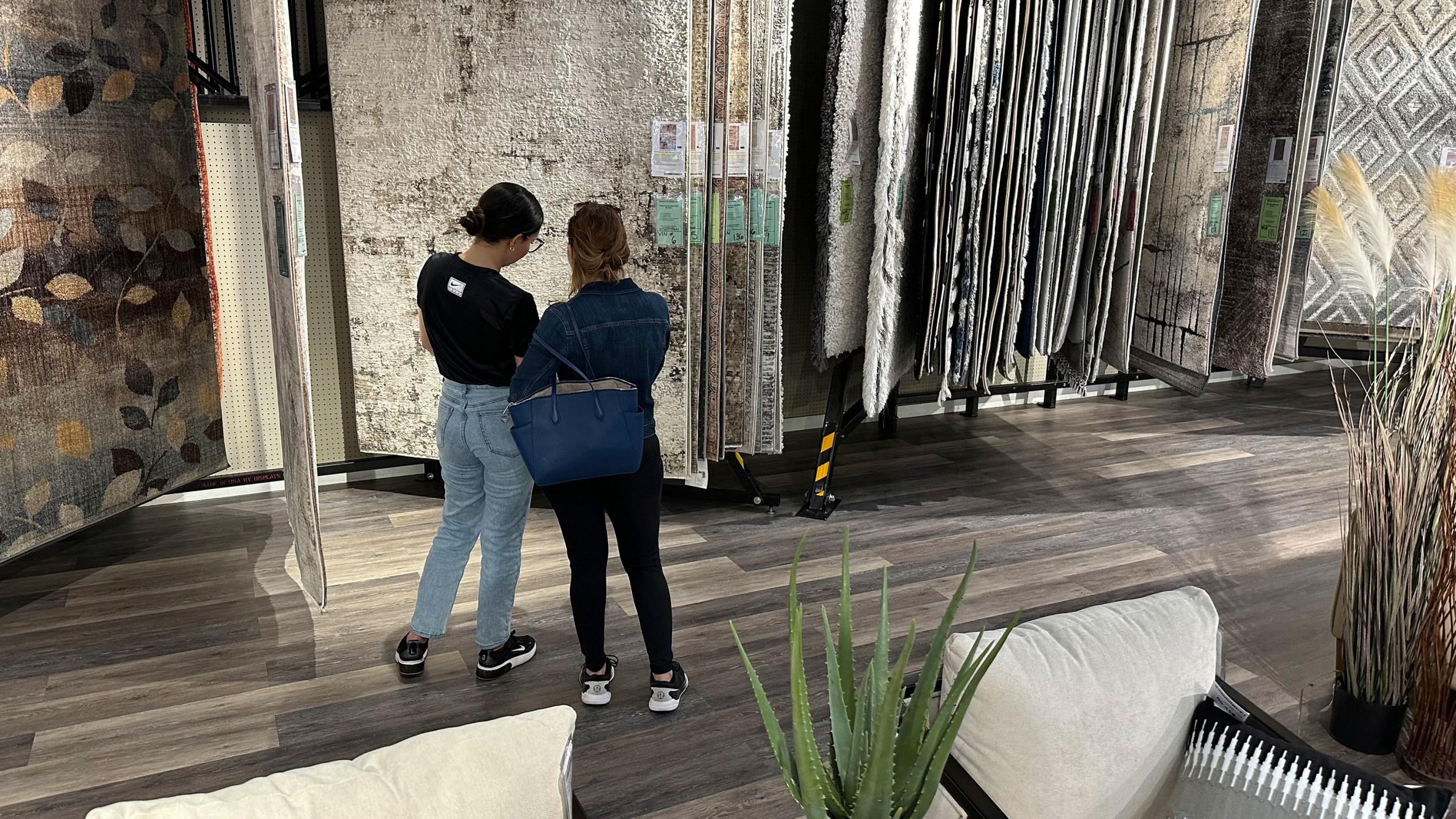 FILE - Shoppers consider rugs on display in a furniture store June 2, 2024, in Lone Tree, Colo. (AP Photo/David Zalubowski, File)