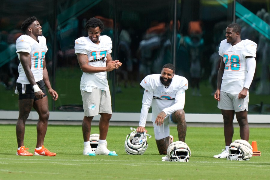 Miami Dolphins wide receiver Odell Beckham Jr., second from right, talks with wide receiver Tyreek Hill (10), wide receiver Jaylen Waddle (17) and running back De'Von Achane (28) during practice at the NFL football team's training facility, Thursday, Oct. 3, 2024, in Miami Gardens, Fla. (AP Photo/Lynne Sladky)