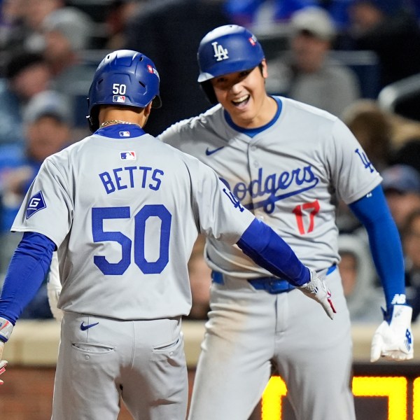 Los Angeles Dodgers' Shohei Ohtani celebrates after scoring on Mookie Betts two-run home run against the New York Mets during the sixth inning in Game 4 of a baseball NL Championship Series, Thursday, Oct. 17, 2024, in New York. (AP Photo/Frank Franklin II)