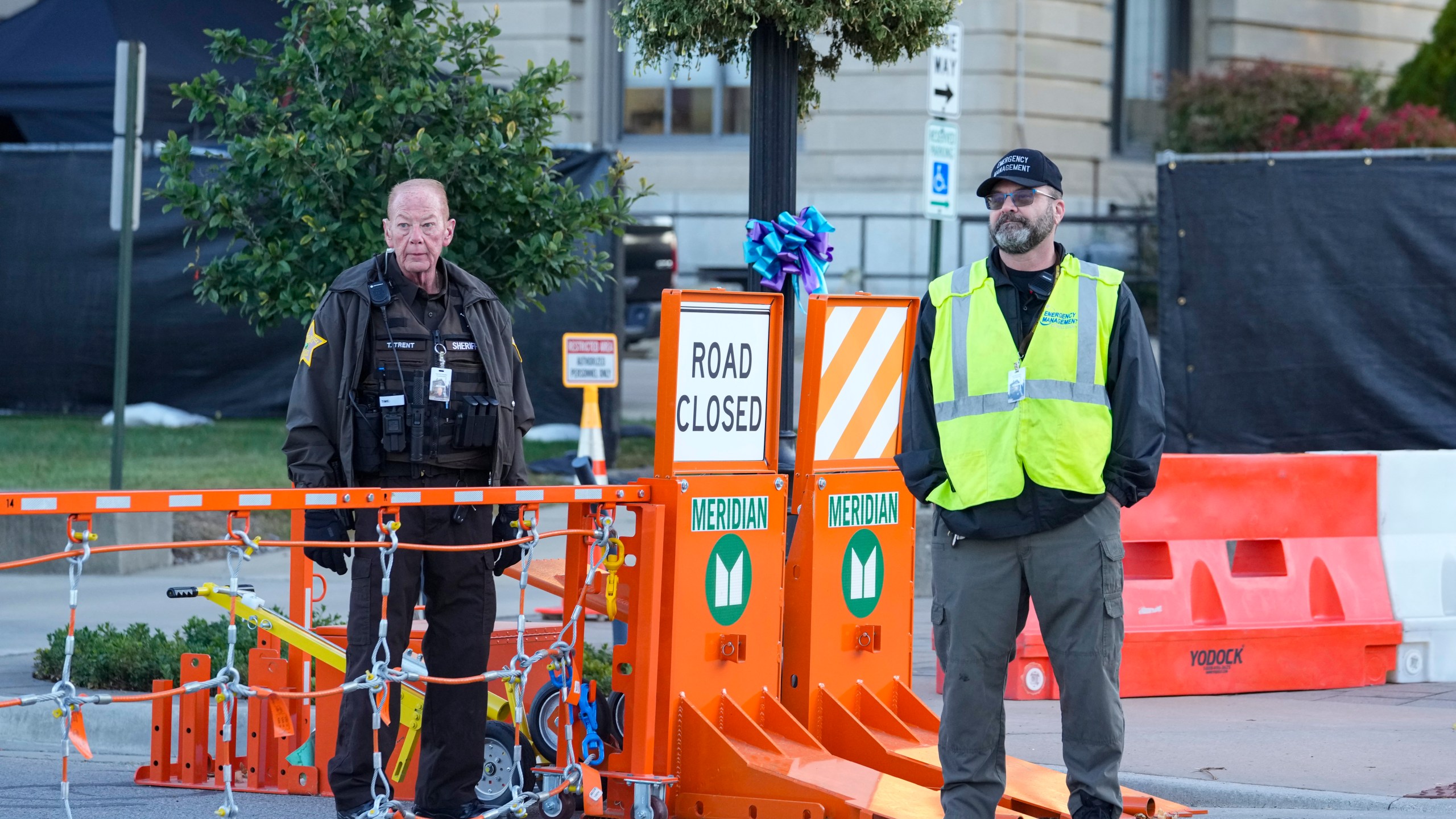 Security stands by a gate outside the Carroll County Courthouse where the trial of Richard Allen, accused of the slayings of two teenage girls in 2017, is set to begin in Delphi, Ind., Friday, Oct. 18, 2024. (AP Photo/Michael Conroy)