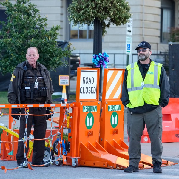 Security stands by a gate outside the Carroll County Courthouse where the trial of Richard Allen, accused of the slayings of two teenage girls in 2017, is set to begin in Delphi, Ind., Friday, Oct. 18, 2024. (AP Photo/Michael Conroy)