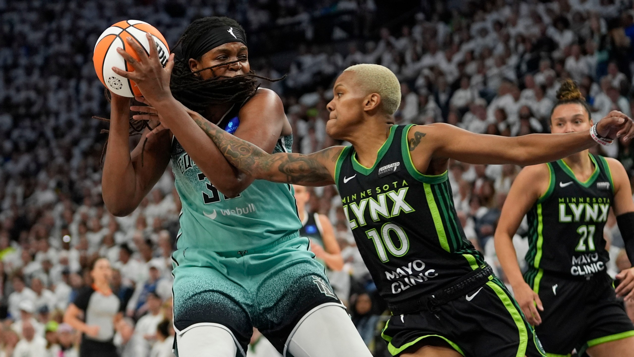 Minnesota Lynx guard Courtney Williams (10) reaches in against New York Liberty forward Jonquel Jones during the first half of Game 4 of a WNBA basketball final playoff series, Friday, Oct. 18, 2024, in Minneapolis. (AP Photo/Abbie Parr)