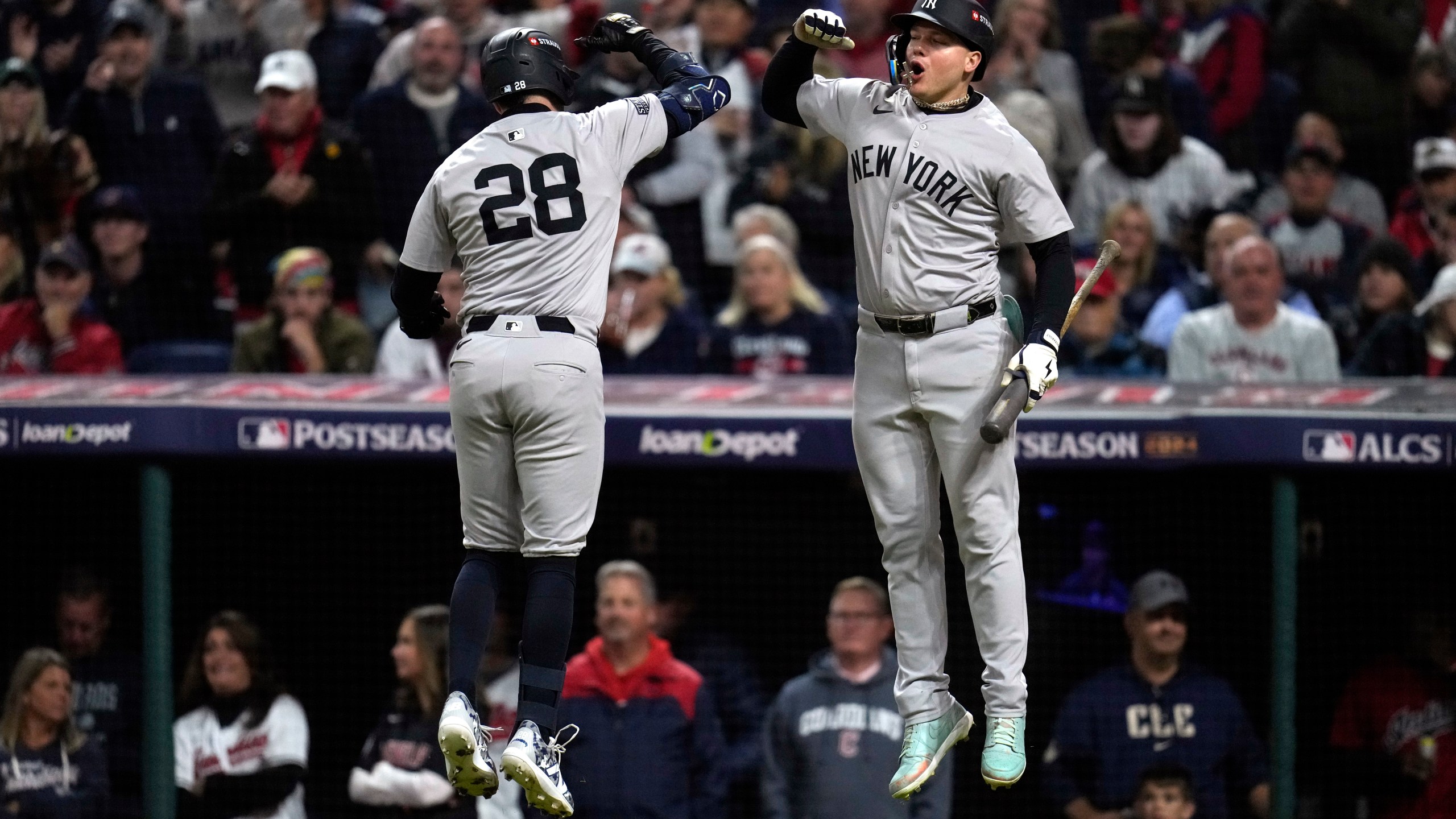 New York Yankees' Austin Wells (28) celebrates with Alex Verdugo after hitting a home run against the Cleveland Guardians during the second inning in Game 4 of the baseball AL Championship Series Friday, Oct. 18, 2024, in Cleveland. (AP Photo/Sue Ogrocki)