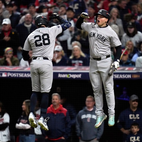 New York Yankees' Austin Wells (28) celebrates with Alex Verdugo after hitting a home run against the Cleveland Guardians during the second inning in Game 4 of the baseball AL Championship Series Friday, Oct. 18, 2024, in Cleveland. (AP Photo/Sue Ogrocki)