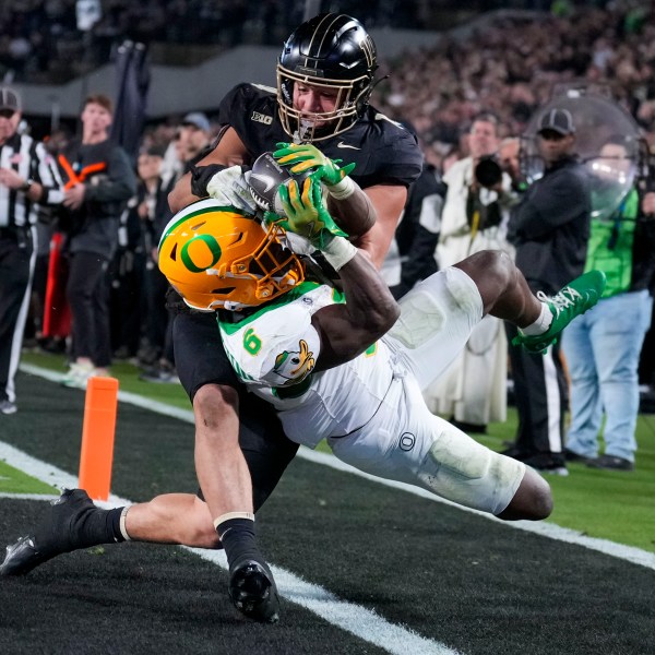 Oregon running back Noah Whittington (6) is forced out of bounds by of Purdue linebacker Yanni Karlaftis, top, after scoring a touchdown during the second half of an NCAA college football game in West Lafayette, Ind., Friday, Oct. 18, 2024. (AP Photo/AJ Mast)