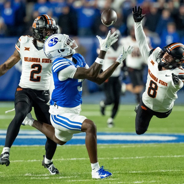 BYU wide receiver Darius Lassiter makes a catch ahead of Oklahoma State cornerback Korie Black (2) and safety Parker Robertson (8) in the first half of an NCAA college football game, Friday, Oct. 18, 2024, in Provo, Utah. (AP Photo/Spenser Heaps)