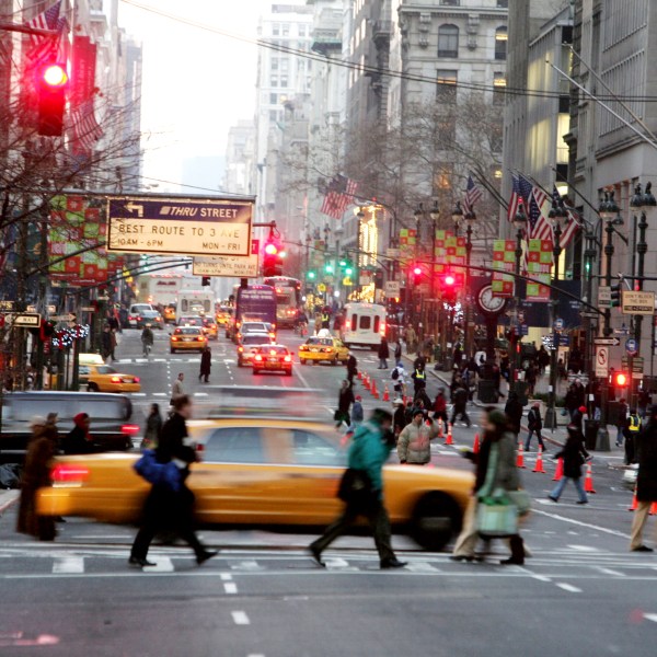 FILE - Vehicles and pedestrians make their way down Fifth Avenue in New York, Dec. 22, 2005, . (AP Photo/Diane Bondareff, File)