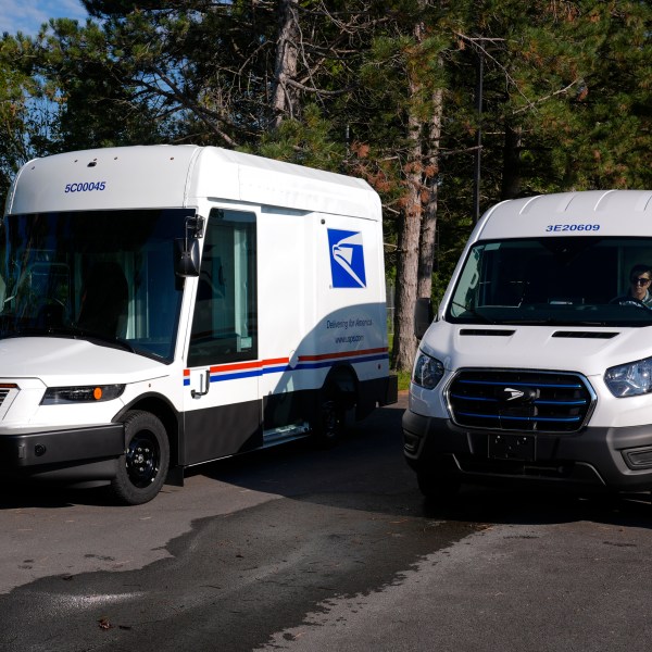 FILE - The U.S. Postal Service's next-generation delivery vehicle, left, is displayed as one new battery electric delivery trucks leaves the Kokomo Sorting and Delivery Center in Kokomo, Ind., Thursday, Aug. 29, 2024. (AP Photo/Michael Conroy, File)