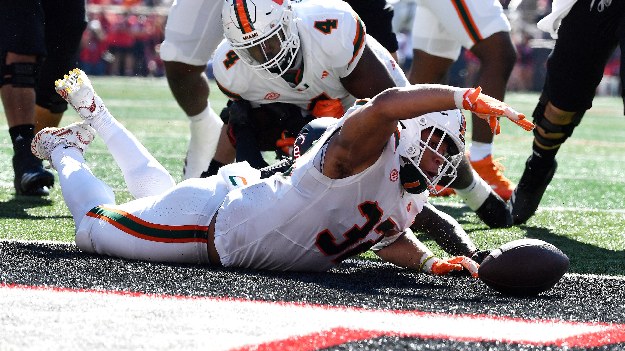 Miami linebacker Raul Aguirre Jr. (32) recovers a Louisville fumble in the end zone to score during the first half of an NCAA college football game in Louisville, Ky., Saturday, Oct. 19, 2024. (AP Photo/Timothy D. Easley)