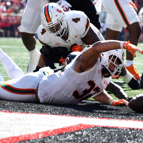 Miami linebacker Raul Aguirre Jr. (32) recovers a Louisville fumble in the end zone to score during the first half of an NCAA college football game in Louisville, Ky., Saturday, Oct. 19, 2024. (AP Photo/Timothy D. Easley)