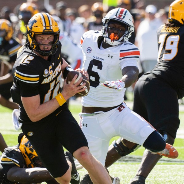 Missouri quarterback Brady Cook, left, spins away from Auburn linebacker Austin Keys during the second half of an NCAA college football game Saturday, Oct. 19, 2024, in Columbia, Mo. Missouri won 21-17. (AP Photo/L.G. Patterson)