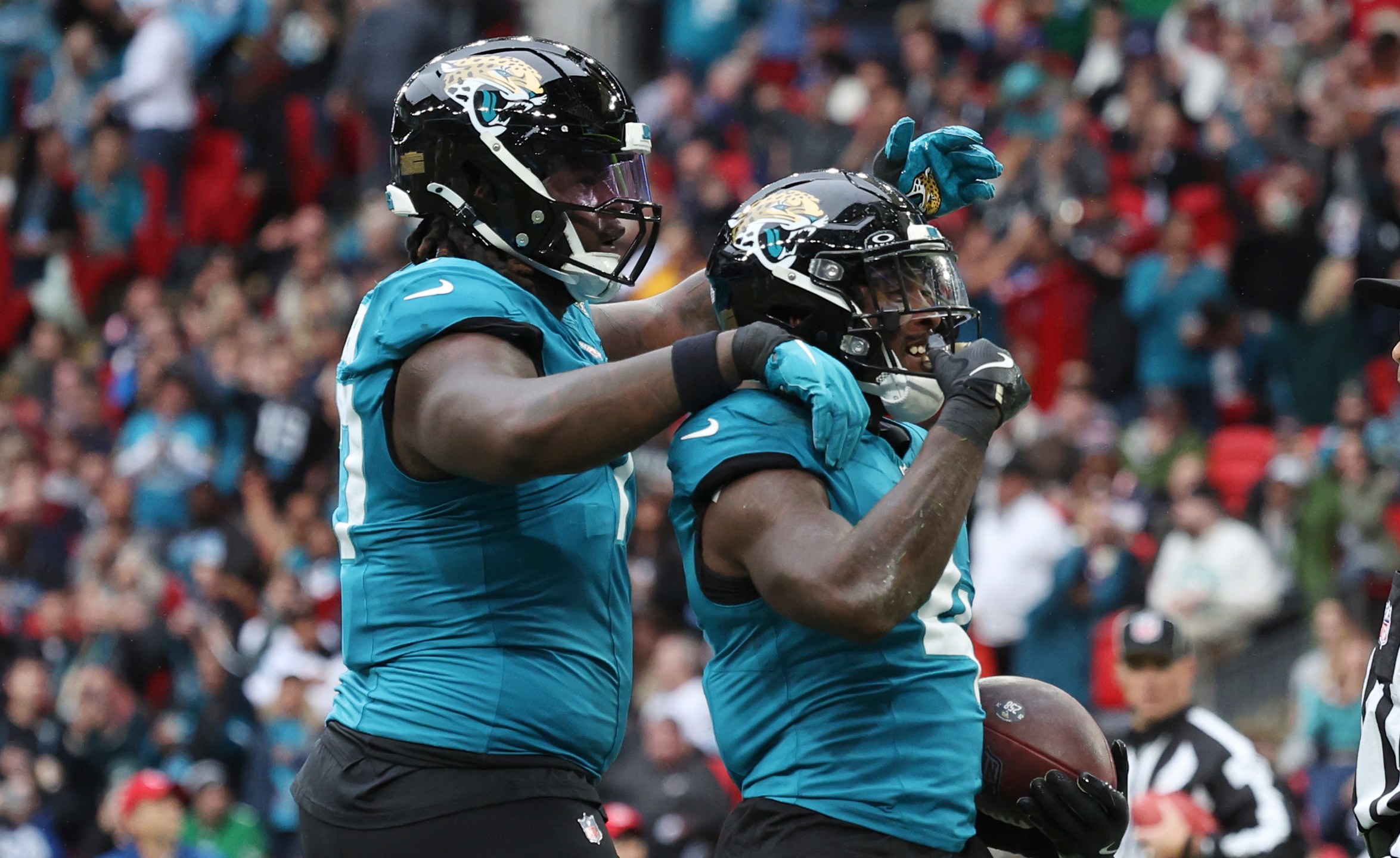 Jacksonville Jaguars running back Tank Bigsby, right, celebrates his 1-yard rushing touchdown during the first half of an NFL football game against the New England Patriots, Sunday, Oct. 20, 2024, in London. (AP Photo/Ian Walton)