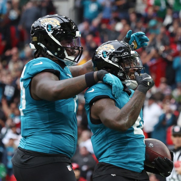 Jacksonville Jaguars running back Tank Bigsby, right, celebrates his 1-yard rushing touchdown during the first half of an NFL football game against the New England Patriots, Sunday, Oct. 20, 2024, in London. (AP Photo/Ian Walton)