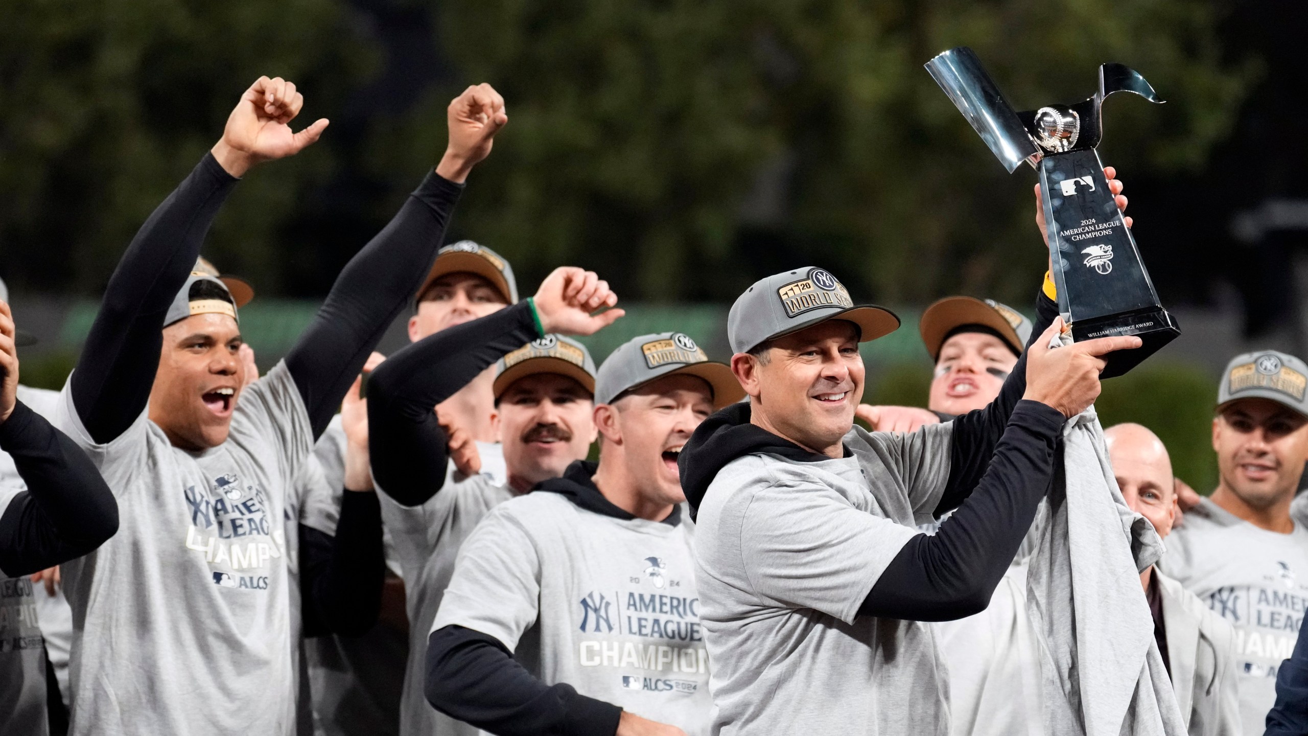 New York Yankees manager Aaron Boone holds up the American League Championship trophy after Game 5 of the baseball AL Championship Series against the Cleveland Guardians Sunday, Oct. 20, 2024, in Cleveland. The Yankees won 5-2 to advance to the World Series. (AP Photo/Sue Ogrocki)