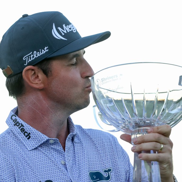 J.T. Poston kisses the trophy after winning the Shriners Children's Open golf tournament, Sunday, Oct. 20, 2024, in Las Vegas. (AP Photo/Ian Maule)