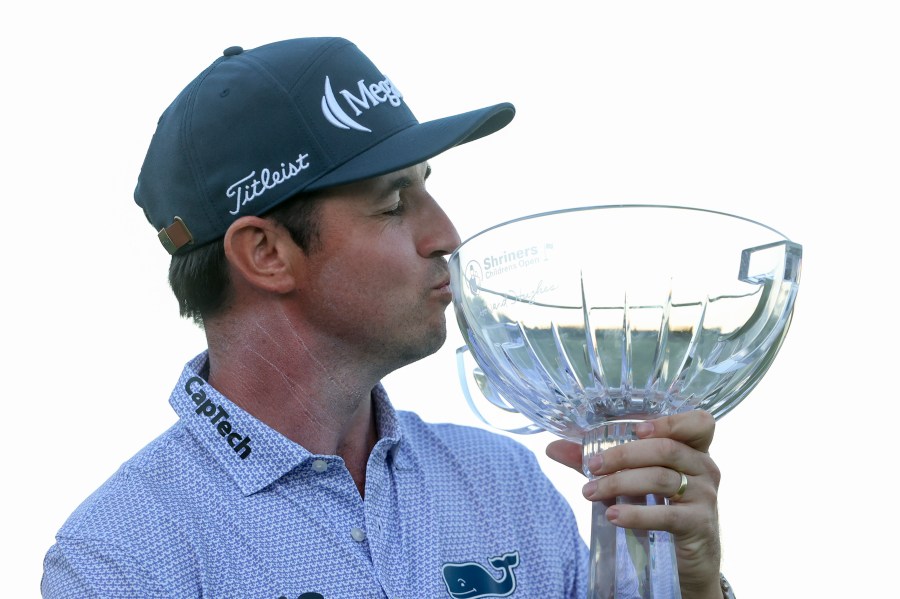 J.T. Poston kisses the trophy after winning the Shriners Children's Open golf tournament, Sunday, Oct. 20, 2024, in Las Vegas. (AP Photo/Ian Maule)