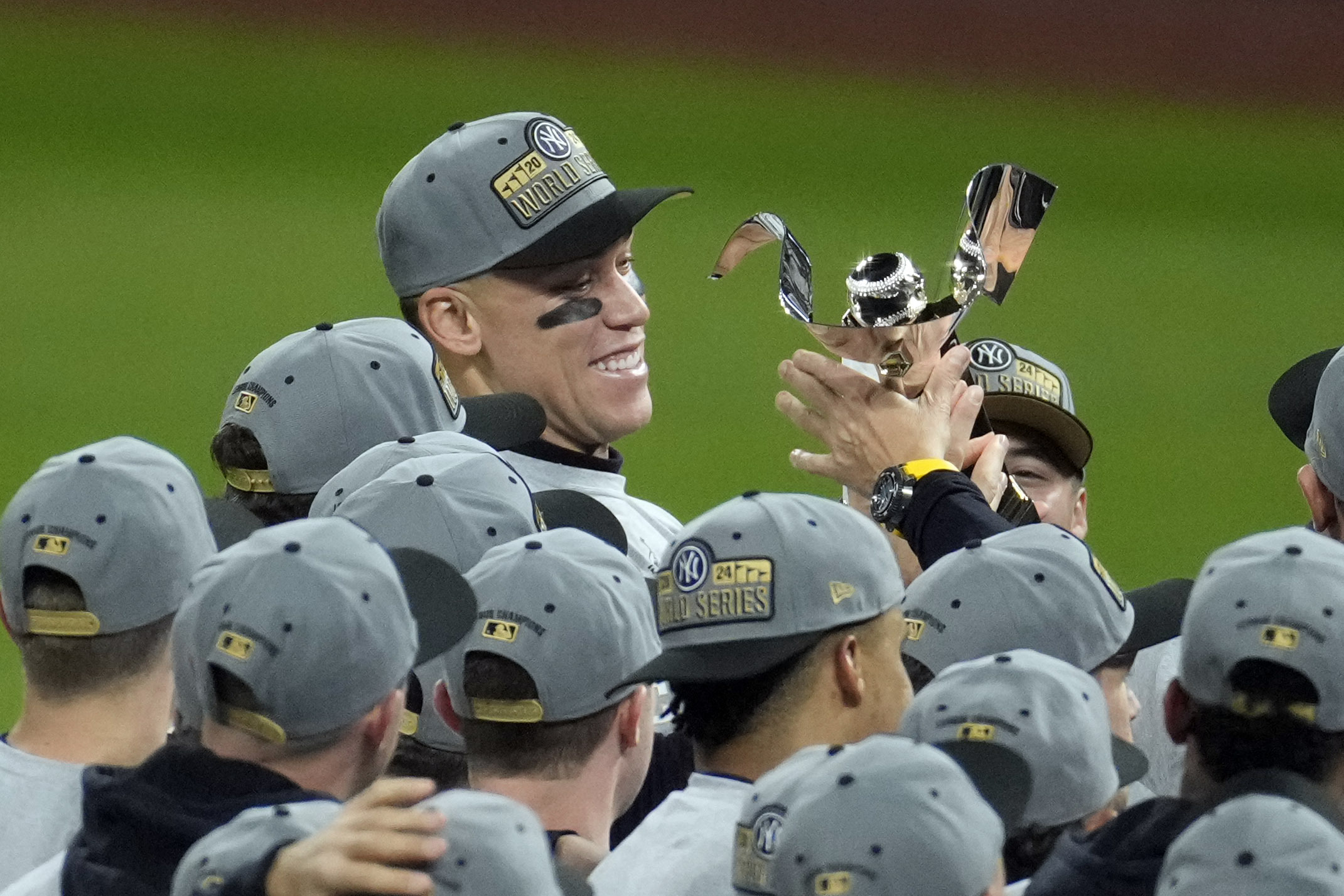 New York Yankees' Aaron Judge holds the American League Championship trophy after Game 5 of the baseball AL Championship Series against the Cleveland Guardians Sunday, Oct. 20, 2024, in Cleveland. The Yankees won 5-2 to advance to the World Series. (AP Photo/Jeff Roberson)