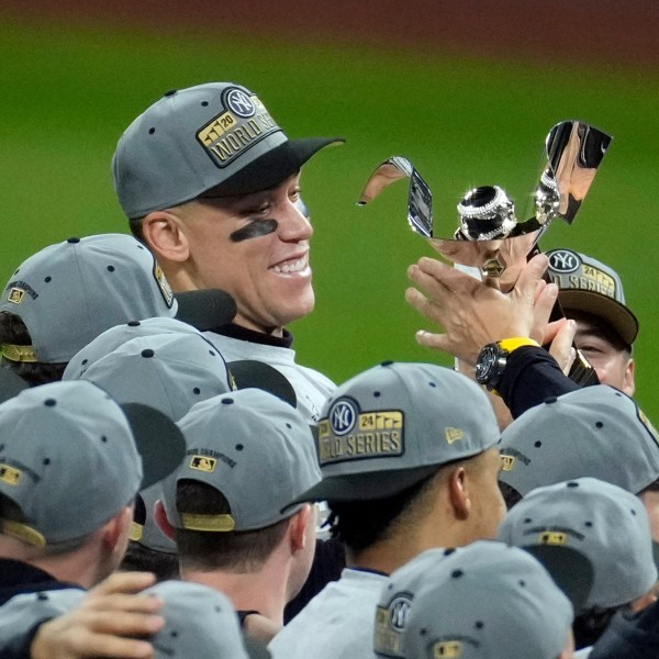 New York Yankees' Aaron Judge holds the American League Championship trophy after Game 5 of the baseball AL Championship Series against the Cleveland Guardians Sunday, Oct. 20, 2024, in Cleveland. The Yankees won 5-2 to advance to the World Series. (AP Photo/Jeff Roberson)