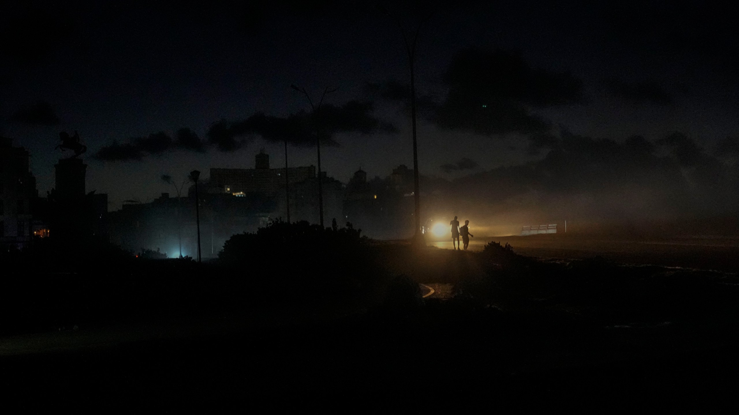 Residents walk on a street during a blackout following the failure of a major power plant in Havana, Cuba, Sunday, Oct. 20, 2024. (AP Photo/Ramon Espinosa)