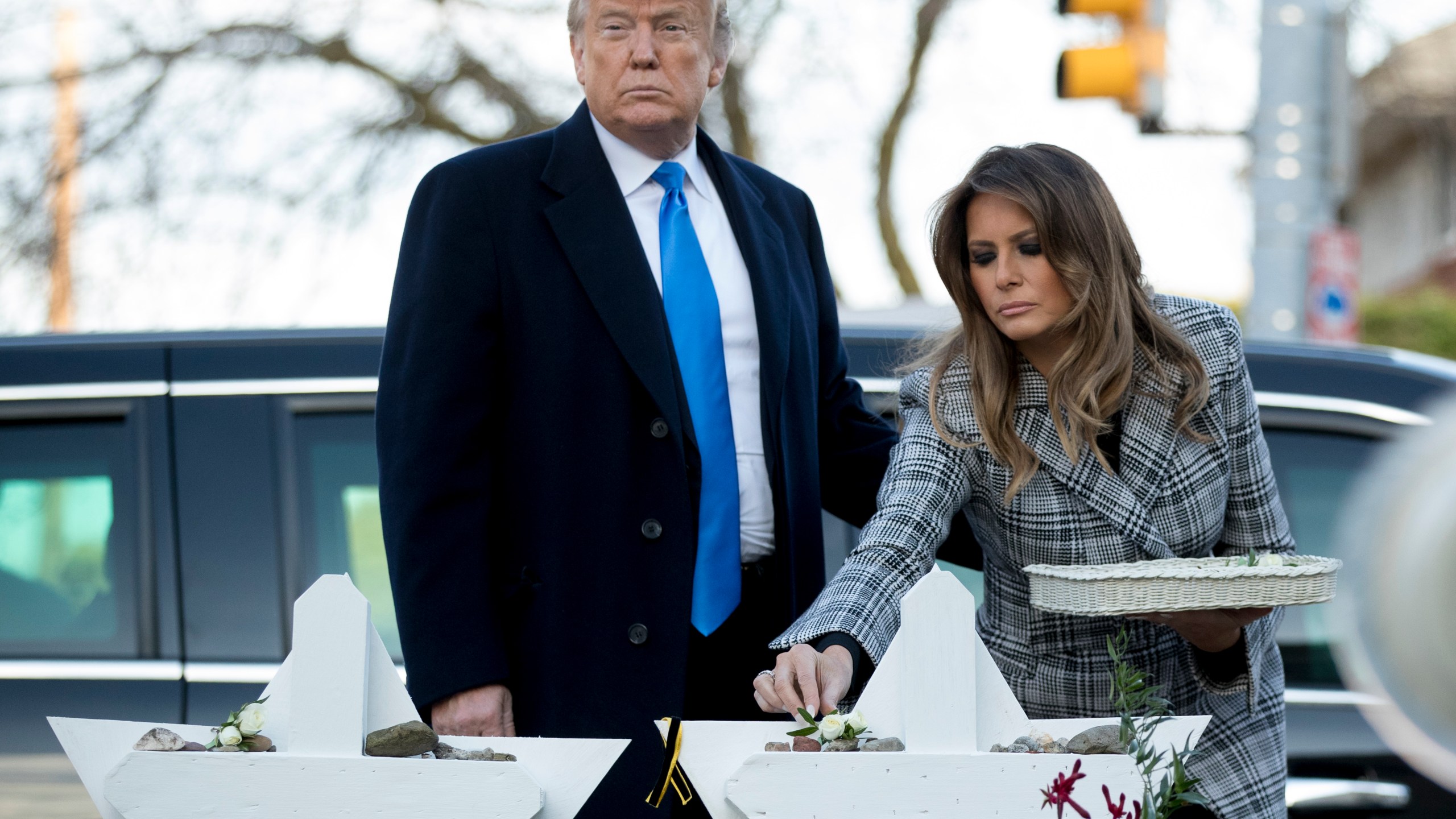 FILE - First lady Melania Trump, accompanied by President Donald Trump, puts down a white flower at a memorial for those killed at the Tree of Life Synagogue in Pittsburgh, Oct. 30, 2018. (AP Photo/Andrew Harnik, File)