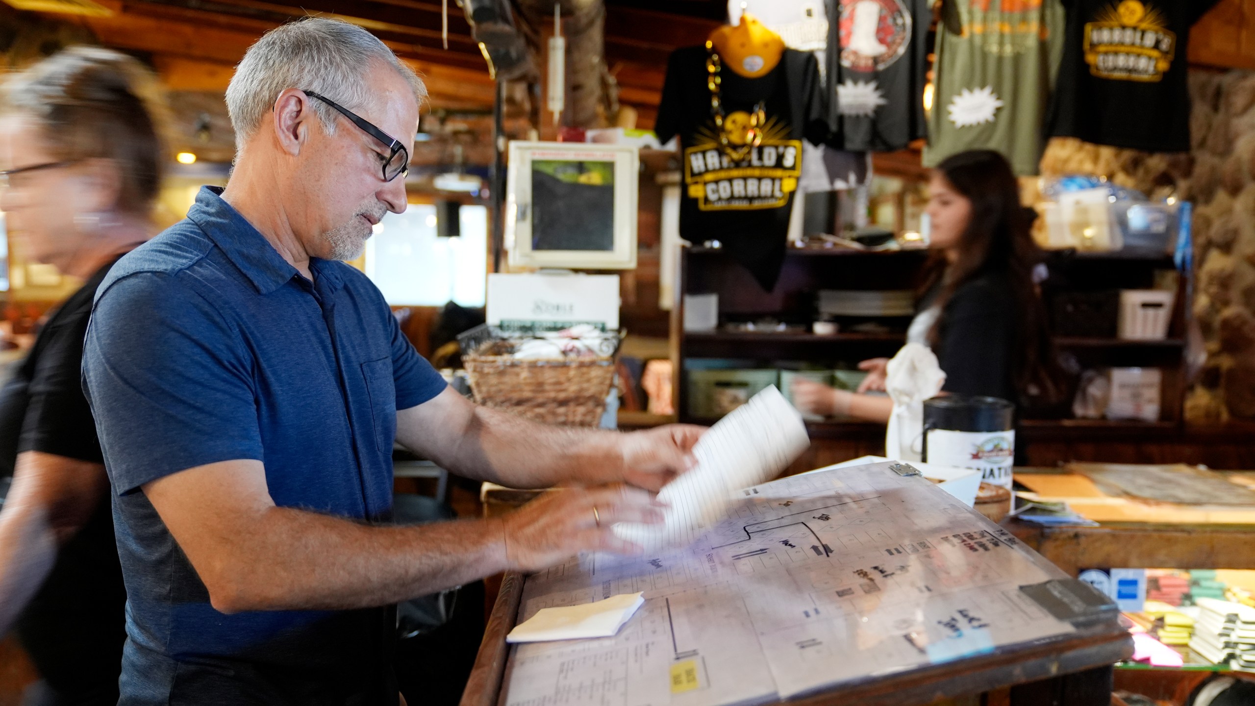 Dan Piacquadio, owner of Harold's Cave Creek Corral, checks for reservations at the entrance of the restaurant as he waits for the upcoming election regarding Arizona Prop 138 on minimum wage Thursday, Oct. 3, 2024, in Cave Creek, Ariz. (AP Photo/Ross D. Franklin)