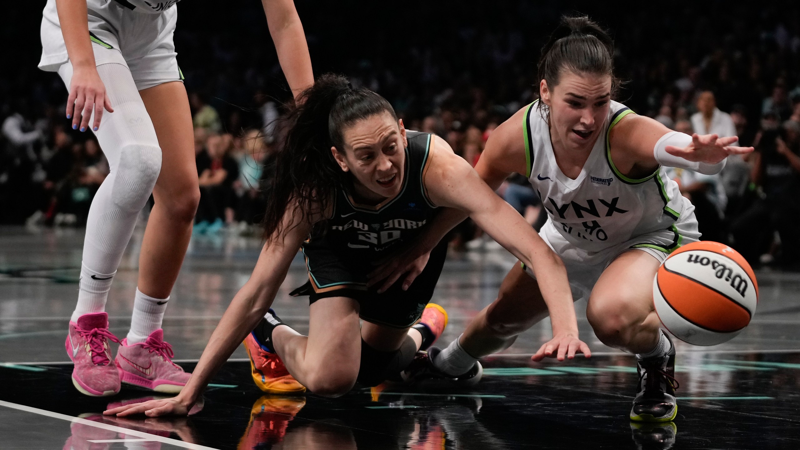 New York Liberty forward Breanna Stewart (30) and Minnesota Lynx forward Bridget Carleton (6) battle for a loose ball during the second quarter of Game 5 of the WNBA basketball final series, Sunday, Oct. 20, 2024, in New York. (AP Photo/Pamela Smith)