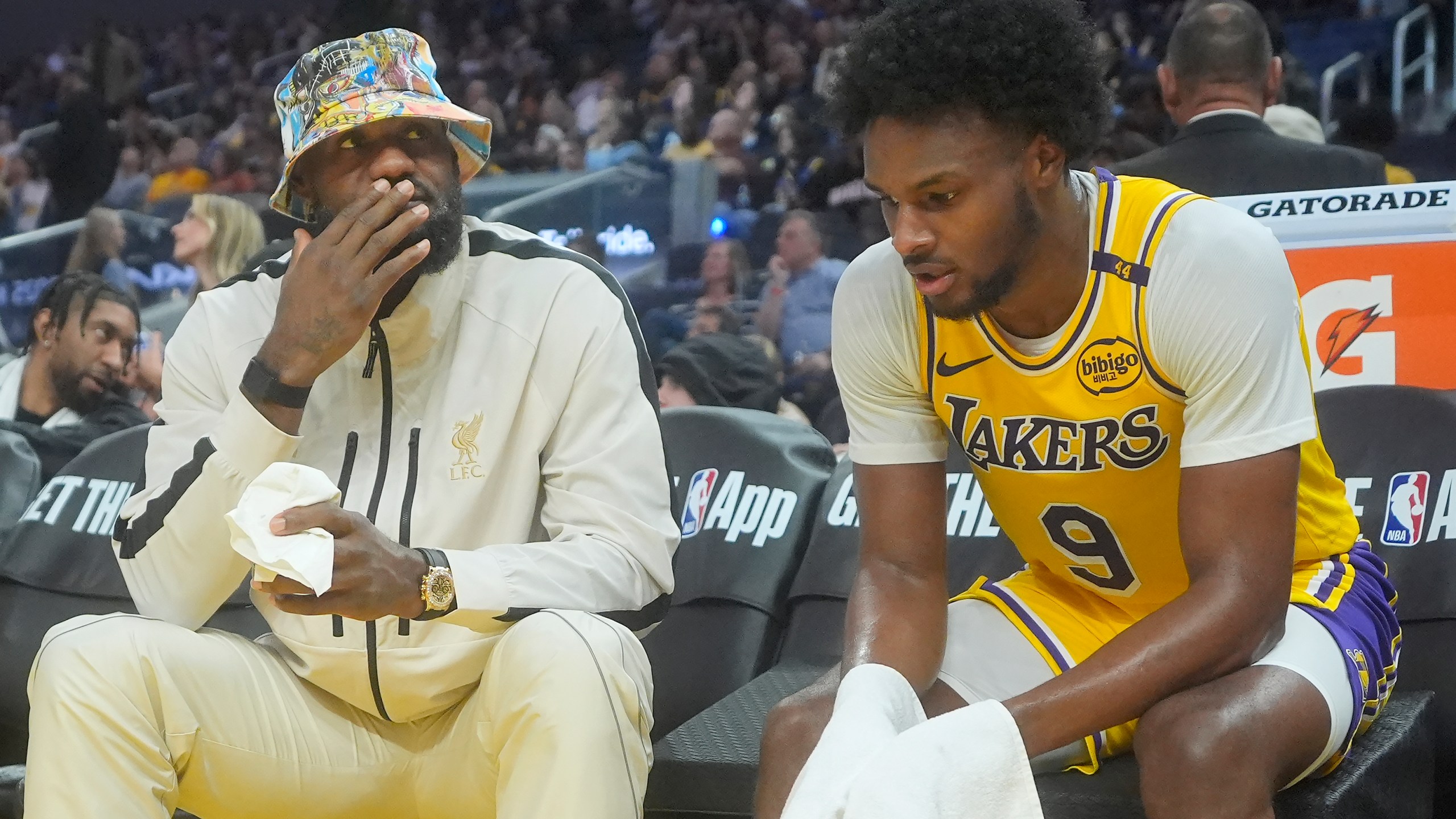 Los Angeles Lakers forward LeBron James, left, talks with guard Bronny James during the second half of an NBA preseason basketball game against the Golden State Warriors in San Francisco, Friday, Oct. 18, 2024. (AP Photo/Jeff Chiu)