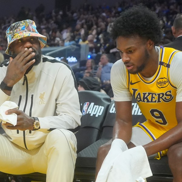 Los Angeles Lakers forward LeBron James, left, talks with guard Bronny James during the second half of an NBA preseason basketball game against the Golden State Warriors in San Francisco, Friday, Oct. 18, 2024. (AP Photo/Jeff Chiu)