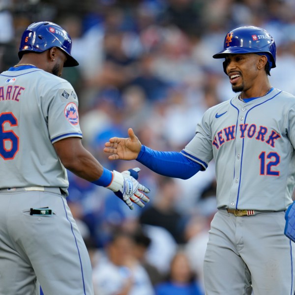 New York Mets' Francisco Lindor celebrates with Starling Marte after scoring on a throwing error by Los Angeles Dodgers second baseman Chris Taylor during the first inning in Game 6 of a baseball NL Championship Series, Sunday, Oct. 20, 2024, in Los Angeles. (AP Photo/Julio Cortez)