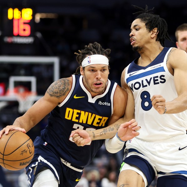 Denver Nuggets forward Aaron Gordon, left, drives past Minnesota Timberwolves forward Josh Minott (8) during the second half of a preseason NBA basketball game, Thursday, Oct. 17, 2024, in Minneapolis. (AP Photo/Matt Krohn)