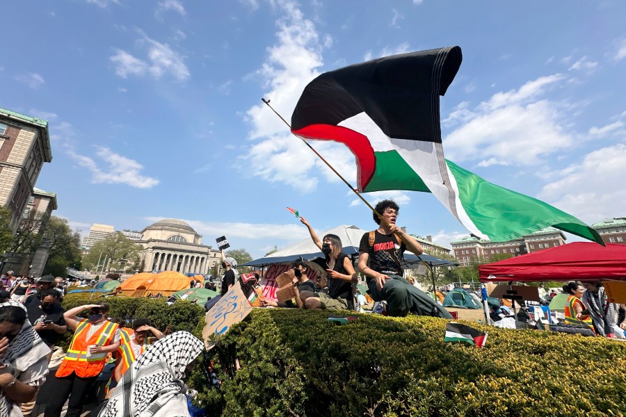 FILE - A demonstrator waves a flag on the Columbia University campus at a pro-Palestinian protest encampment, in New York, April 29, 2024. (AP Photo/Ted Shaffrey, File)