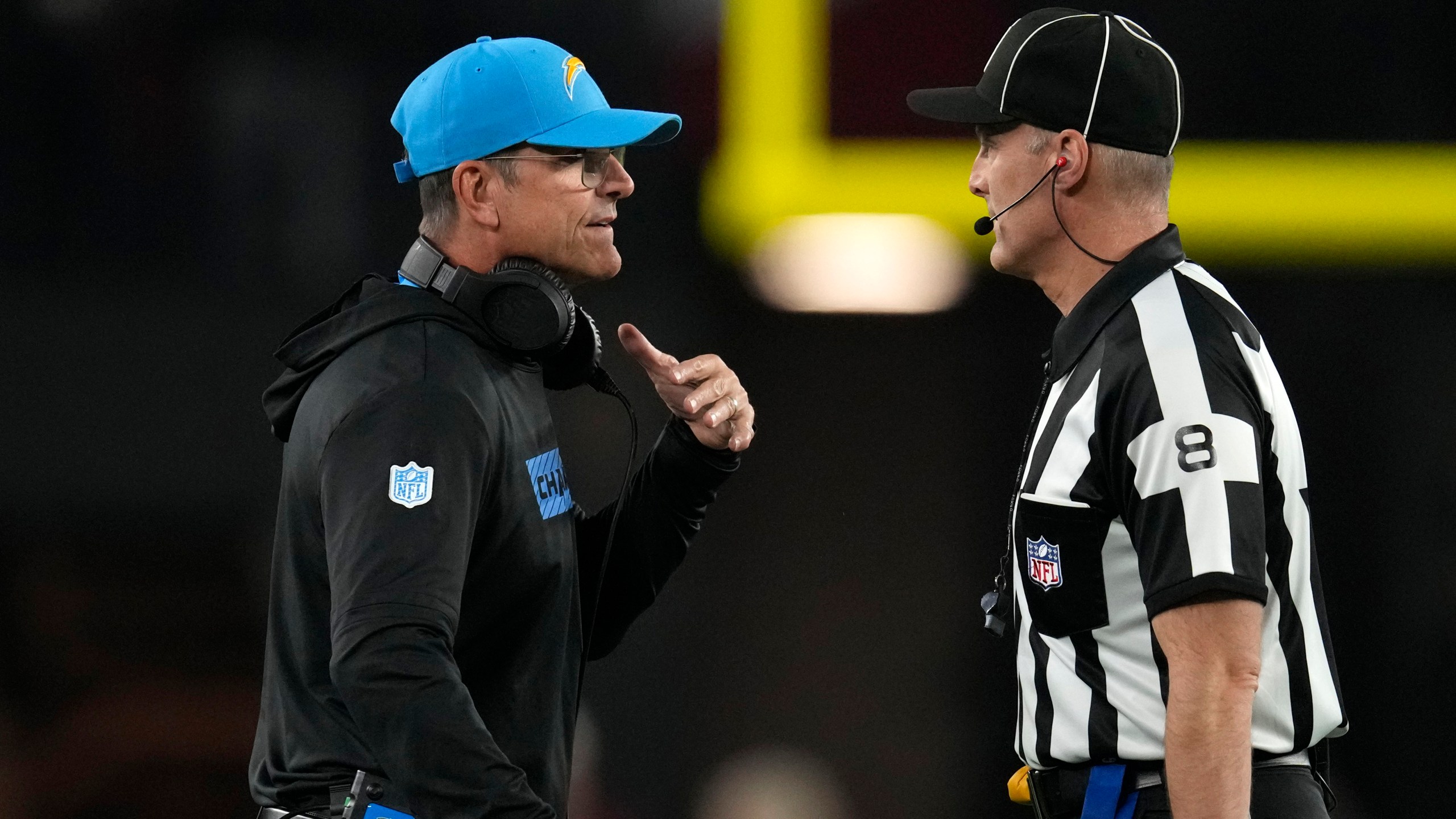 Los Angeles Chargers head coach Jim Harbaugh, left, talks with down judge Dana McKenzie, right, during the first half of an NFL football game against the Arizona Cardinals, Monday, Oct. 21, 2024, in Glendale Ariz. (AP Photo/Matt York)