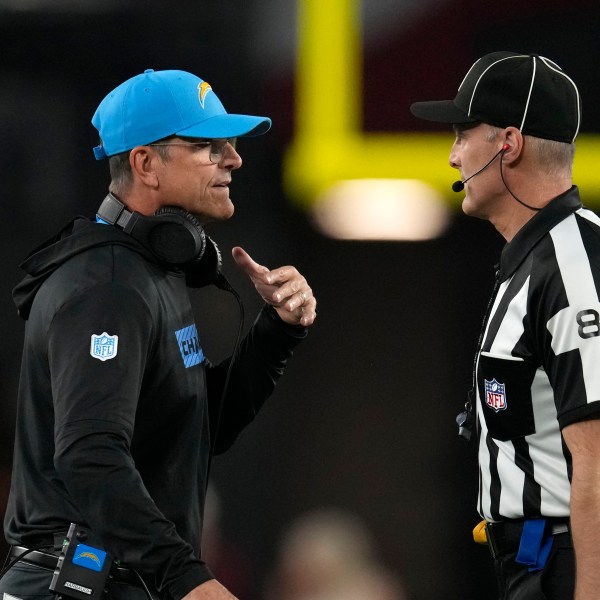 Los Angeles Chargers head coach Jim Harbaugh, left, talks with down judge Dana McKenzie, right, during the first half of an NFL football game against the Arizona Cardinals, Monday, Oct. 21, 2024, in Glendale Ariz. (AP Photo/Matt York)