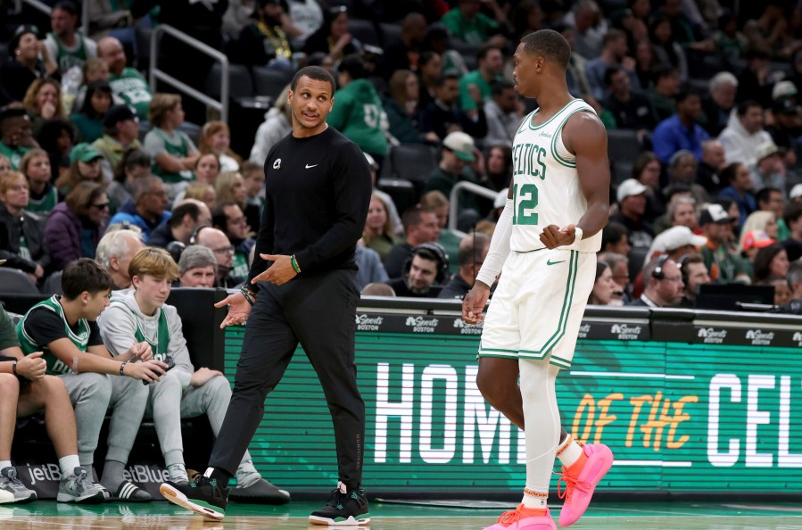 Boston Celtics head coach Joe Mazzulla, front left, speaks with Boston Celtics guard Lonnie Walker IV (12) who walks to the team bench during the second half of a preseason NBA basketball game against the Toronto Raptors, Sunday, Oct. 13, 2024, in Boston. (AP Photo/Mark Stockwell)