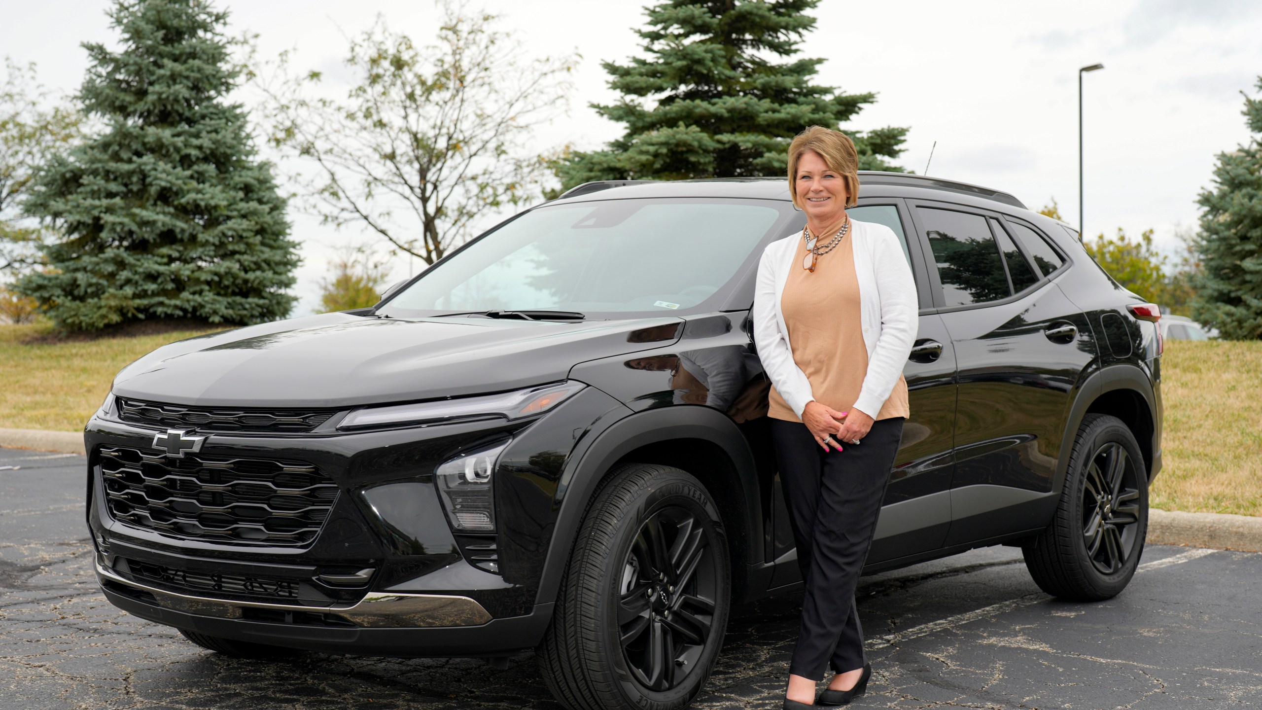 Michelle Chumley poses for a portrait beside her new Chevrolet Trax compact SUV, Thursday, Sept. 26, 2024, in West Chester, Ohio. (AP Photo/Jeff Dean)