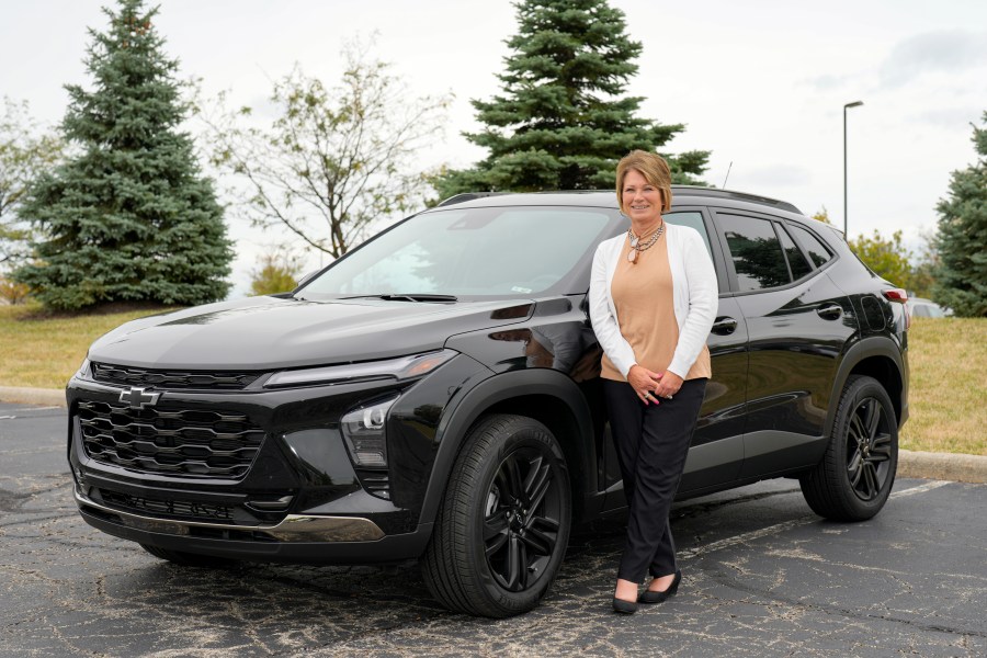 Michelle Chumley poses for a portrait beside her new Chevrolet Trax compact SUV, Thursday, Sept. 26, 2024, in West Chester, Ohio. (AP Photo/Jeff Dean)