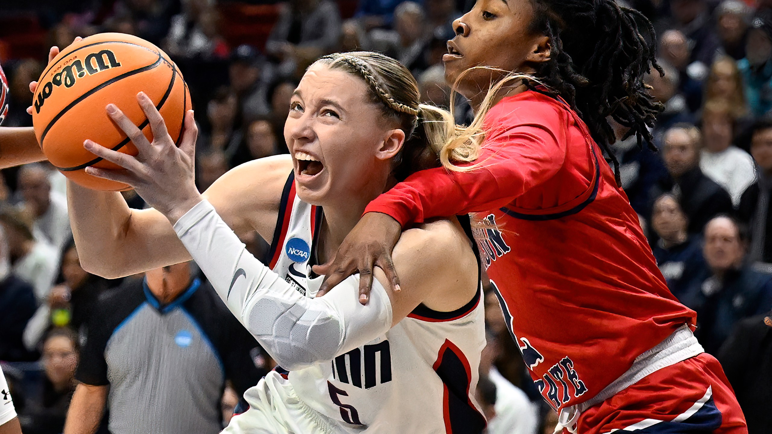 FILE - UConn guard Paige Bueckers, left, is fouled by Jackson State guard Miya Crump in the first half of a first-round college basketball game in the NCAA Tournament, Saturday, March 23, 2024, in Storrs, Conn. (AP Photo/Jessica Hill, File)