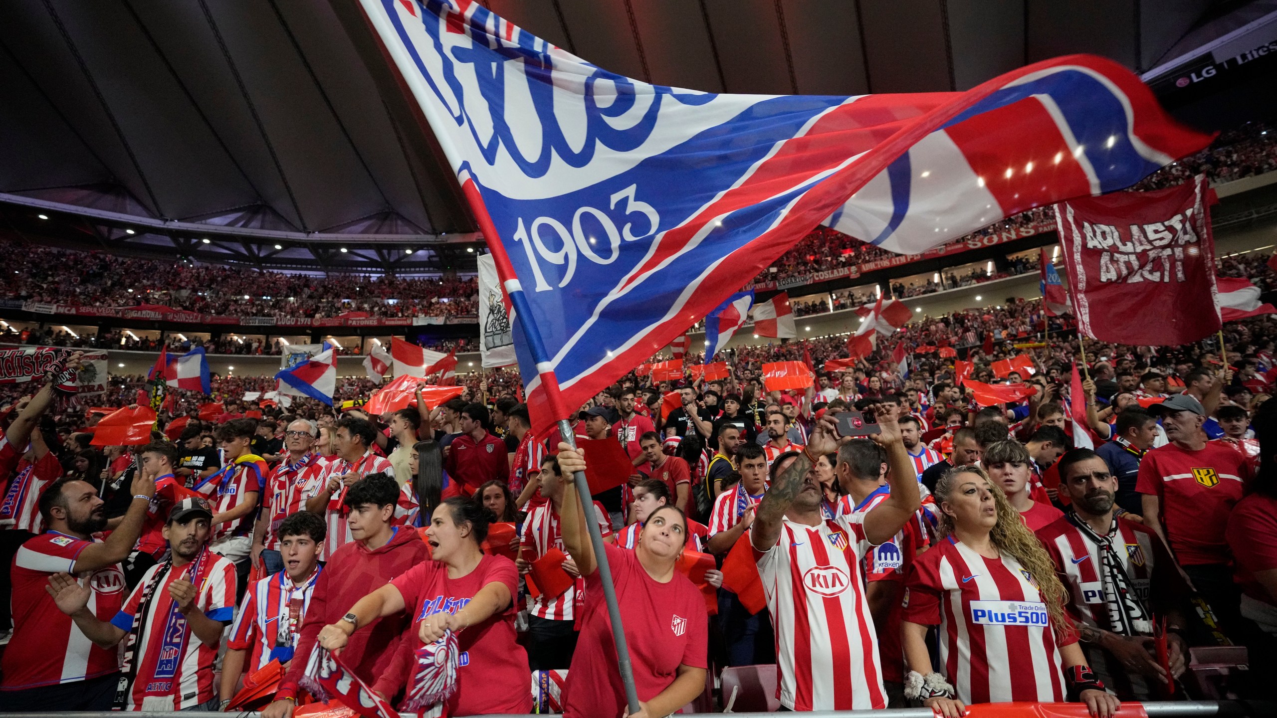 Atletico fans cheer before the La Liga soccer match between Atletico Madrid and Real Madrid at the Metropolitano stadium in Madrid, Spain, Sunday, Sept. 29, 2024. (AP Photo/Bernat Armangue)