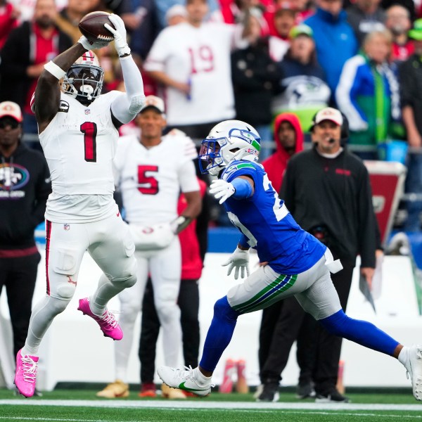 San Francisco 49ers wide receiver Deebo Samuel Sr. (1) makes a catch against Seattle Seahawks safety Julian Love, right, and would run it in for a touchdown during the first half of an NFL football game, Thursday, Oct. 10, 2024 in Seattle. (AP Photo/Lindsey Wasson)