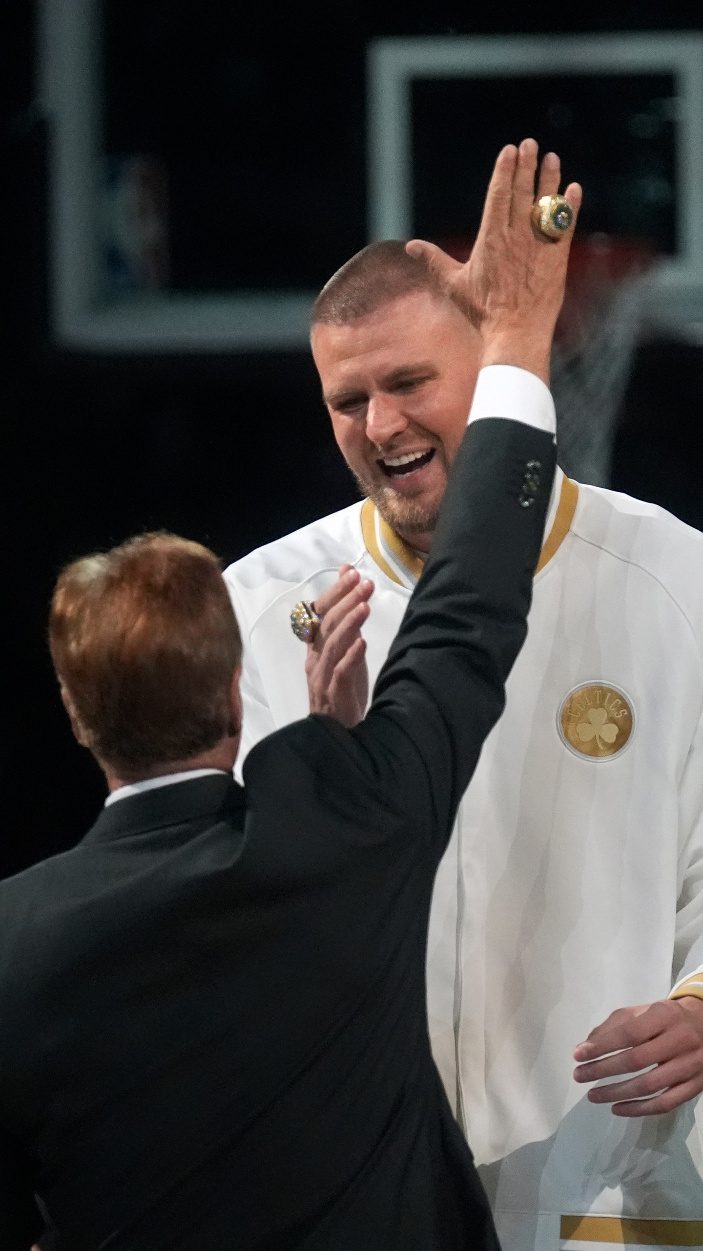 Boston Celtics center Kristaps Porzingis, celebrates with team owner Steve Pagliuca during a ceremony where the 2024 NBA Championship banner was raised prior to an NBA basketball game against the New York Knicks, Tuesday, Oct. 22, 2024, in Boston. (AP Photo/Charles Krupa)